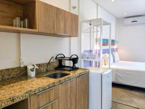 a kitchen with a sink and a refrigerator and a bed at Saint Germain Wind Residence in Icaraí +28 photos