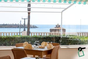 a table with napkins on it with a view of the ocean at Hotiday Leuca Porto in Leuca