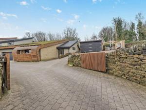 a stone wall next to a building with a fence at 3 Bed in Sheffield oc-94342 in Thurlstone