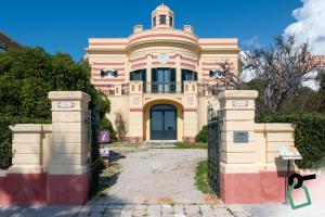a pink house with a gate in front of it at Hotiday Leuca Porto in Leuca