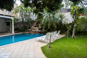 a group of chairs sitting next to a swimming pool at Nobile Hotel Premier Hill in Asunción