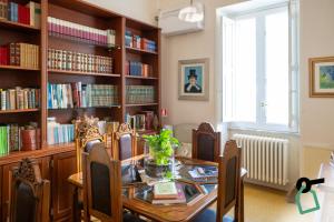 a dining room with a table and bookshelves at Hotiday Leuca Porto in Leuca