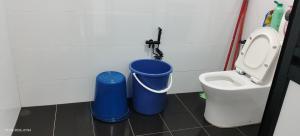 a bathroom with two blue trash cans and a toilet at Homestay Rumah 311 in Sungai Petani +5 photos