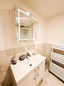a bathroom with a white sink and a mirror at Broadweavers - Very Cute Cottage In Dursley By STAE-Homes in Gloucestershire