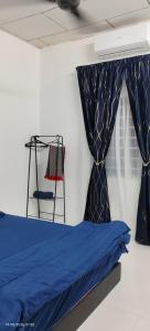 a bedroom with a blue bed and a chair at Homestay Rumah 311 in Sungai Petani