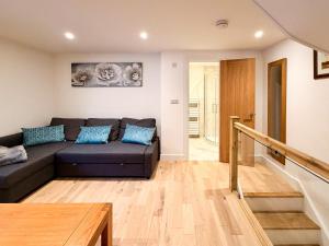 a living room with a couch and a wooden floor at Broadweavers - Very Cute Cottage In Dursley By STAE-Homes in Gloucestershire
