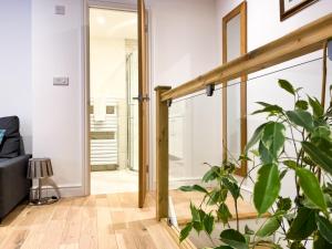 a pivot door in a living room with a plant at Broadweavers - Very Cute Cottage In Dursley By STAE-Homes in Gloucestershire