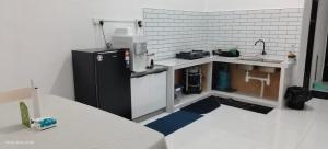 a kitchen with a black refrigerator and a counter at Homestay Rumah 311 in Sungai Petani