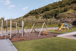 a playground with two swings and a slide at Residence Fallrohrhof in Naturno