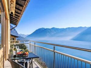 a table on a balcony with a view of the mountains at Apartment Miralago by Interhome in Oria