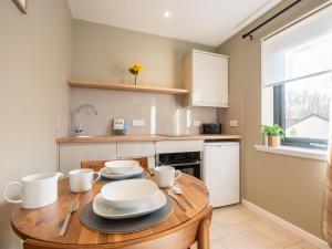 a kitchen with a wooden table with dishes on it at Apartment Wayside Loft by Interhome in Drumnadrochit