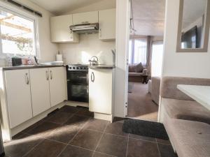 a kitchen with white cabinets and a stove top oven at Cornholme Lodge in Accrington