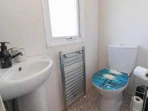 a bathroom with a sink and a toilet with a blue seat at Cornholme Lodge in Accrington +13 photos