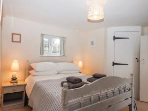 a bedroom with a bed with towels on it at Yew Tree Cottage in Dartmouth