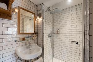 a white bathroom with a sink and a mirror at The White Hart in Stockbridge +51 photos