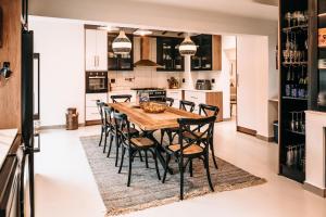 a kitchen and dining room with a wooden table and chairs at Lagoon Haven House in Hermanus