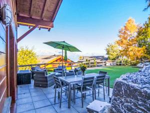 a patio with a table with chairs and an umbrella at Chalet La Balance by Interhome in Nendaz