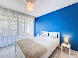 a blue bedroom with a bed and a blue wall at Apartment Kérabus-3 by Interhome in Quiberon