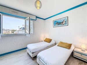 two beds in a room with a window at Apartment Kérabus-3 by Interhome in Quiberon