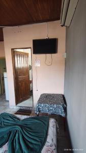 a room with two beds and a flat screen tv at Pousada Itararé in São Vicente