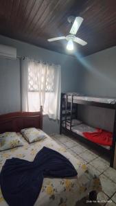 a bedroom with two bunk beds and a ceiling fan at Pousada Itararé in São Vicente