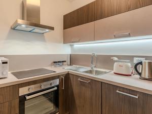 a kitchen with wooden cabinets and a sink at Apartment Ilaria by Interhome in Riva del Garda +27 photos