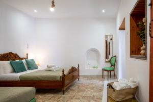 a bedroom with a bed and a green chair at Old Town Nest in Rhodes Town