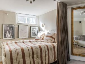 a bedroom with a bed with a striped blanket at Apartment Vårhemsplatsen by Interhome in Halmstad