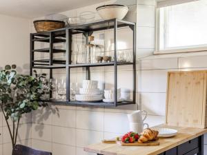 a kitchen counter with a shelf with dishes on it at Apartment Vårhemsplatsen by Interhome in Halmstad +20 photos