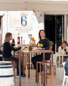 two women sitting at a table in a restaurant at Sei Stelle Mama in Polignano a Mare