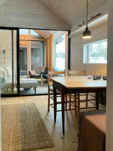 a dining room with a table and a living room at Mountain Cabin With Sauna At Blefjell in Lampeland