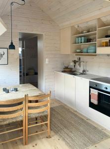 a kitchen with a wooden table and a kitchen counter at Mountain Cabin With Sauna At Blefjell in Lampeland
