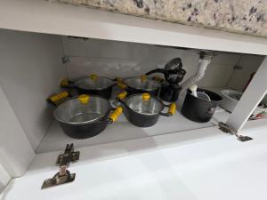 a kitchen sink with four pots on a shelf at Apartamento Aconchegante 103 Palmeiras de Goiás in Palmeiras de Goiás