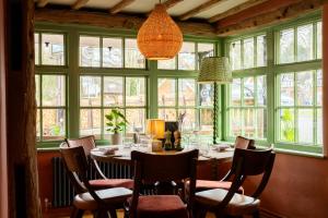 a dining room with a table and chairs and windows at The White Hart in Stockbridge