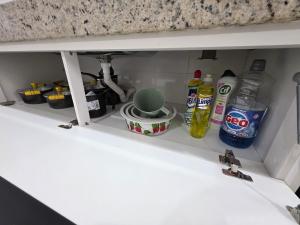 a kitchen shelf with food and drinks on it at Apartamento Aconchegante 103 Palmeiras de Goiás in Palmeiras de Goiás