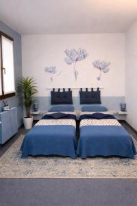 a bedroom with three beds with blue pillows at La Casa Blu- Forum di Assago, Humanitas, Milanofiori, IEO in Rozzano