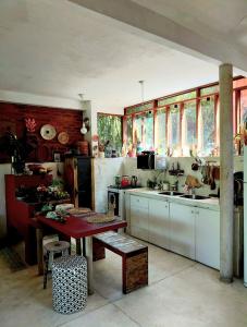 a kitchen with a table and a sink and windows at Casa de vidro in Petrópolis