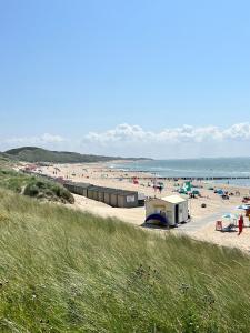 a beach with a bunch of people on the sand at De Spaier 3a in Zoutelande