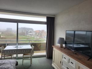 a hotel room with a large window and a television at Studio Residentie Astrid Bredene in Bredene