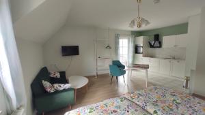 a living room with a bed a table and a kitchen at Ferienhaus Moselpanorama in Ellenz-Poltersdorf