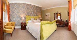 a bedroom with a bed and a chair and a mirror at Beaumont Windermere - Adults-Only Boutique Guest House- Free Parking & Wellness Access in Windermere