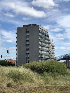 a tall building in the middle of a field at Studio Residentie Astrid Bredene in Bredene