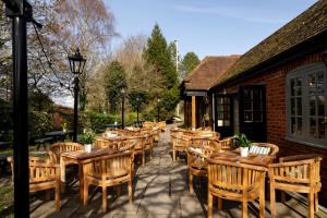 a row of wooden tables and chairs on a patio at The White Hart in Stockbridge