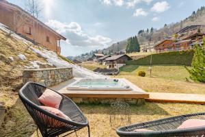 a patio with two chairs and a swimming pool at Hameau des clos Virolet in Les Gets