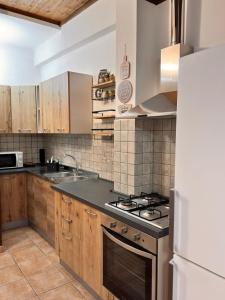 a kitchen with wooden cabinets and a stove top oven at Casa sul mare da Giovanna in La Caletta