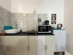 a kitchen with a counter top with a microwave at Diamond Stay Inn in Dhangethi +1 photo