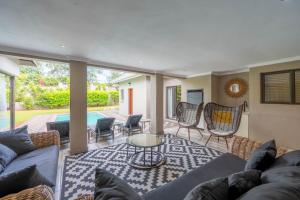 a living room with a couch and chairs and a table at The House in Hazyview