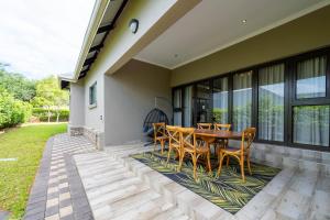 a patio with a wooden table and chairs at The House in Hazyview