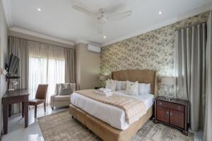 a bedroom with a large bed and a desk at The House in Hazyview +48 photos