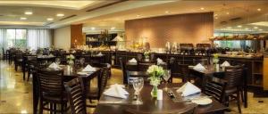 a restaurant with tables and chairs and a bar at Sol Alphaville Hotel & Residence 1004 in Barueri